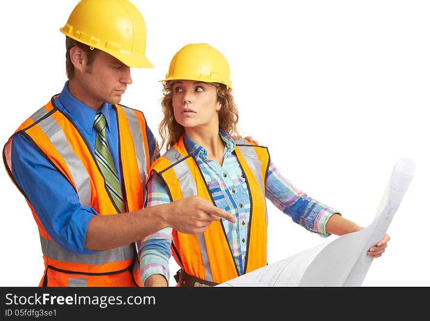 Attractive male and female construction workers looking at blueprints isolated on white.