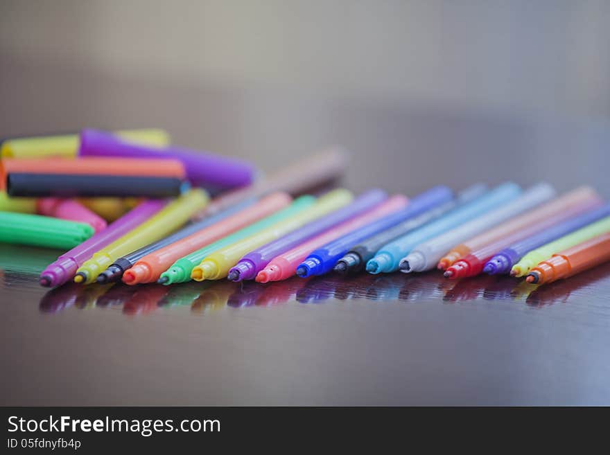 Colored markers lie in a row on the table