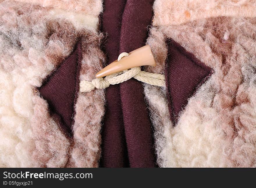 A plastic horn toggle fastener with a rope loop on a vest of a sheepskin