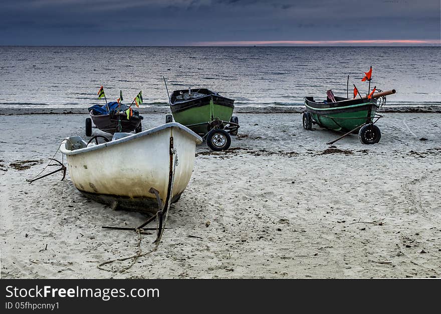 The fishing boats were photographed at the early morning on the beach of Baltic Sea, Latvia, Europe. The fishing boats were photographed at the early morning on the beach of Baltic Sea, Latvia, Europe