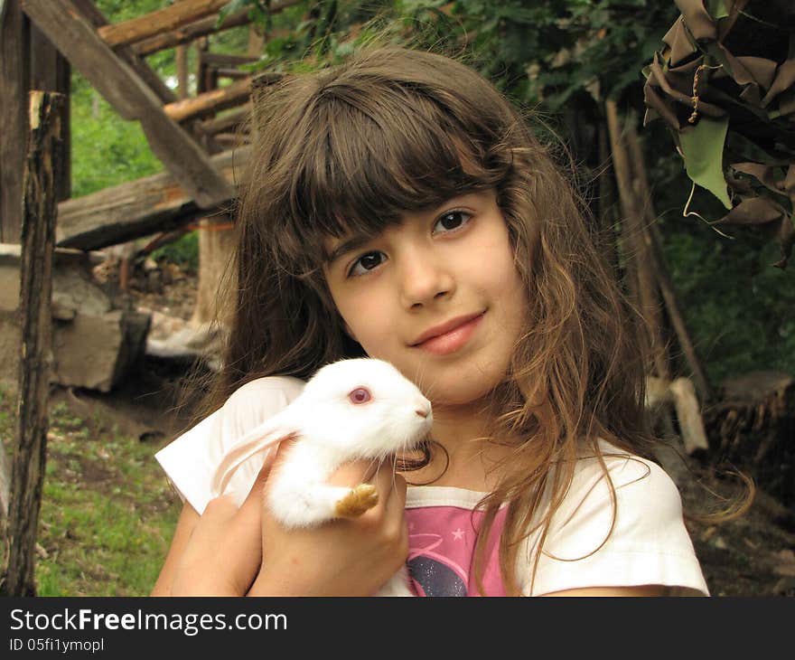 Portrait of happy little girl with adorable white rabbit. Portrait of happy little girl with adorable white rabbit