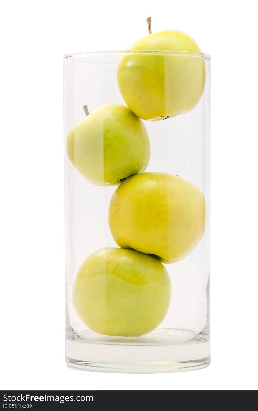 Four yellow apples in big glass on white background isolated.