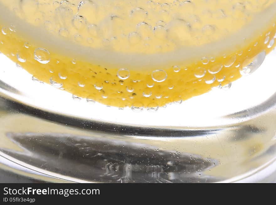 Bubbles on a lemon slice in soda water. Bubbles on a lemon slice in soda water