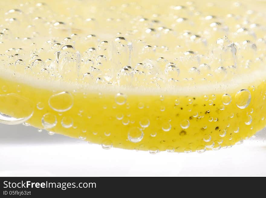 Bubbles on a lemon slice in soda water. Bubbles on a lemon slice in soda water