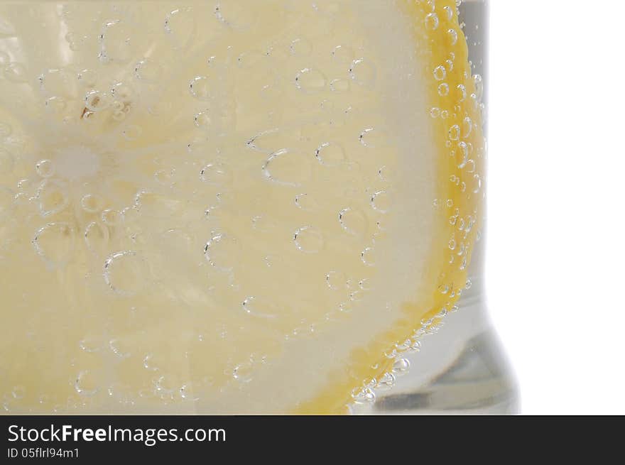 Bubbles on a lemon slice in soda water. Bubbles on a lemon slice in soda water