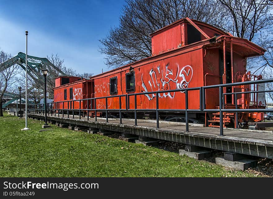 Old orange train with a steel bridge in the background