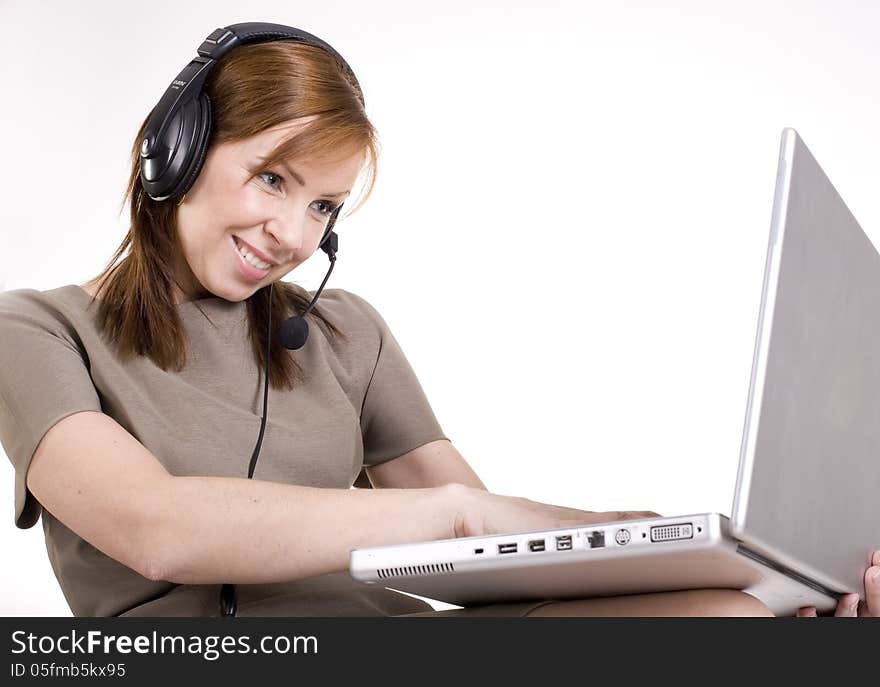 Portrait of pretty call operator smiling and typing on lap top