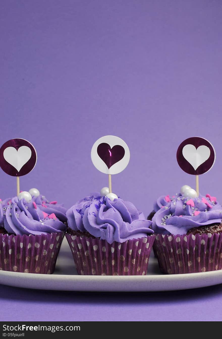 Mauve purple decorated cupcakes for children or teens birthday, or bachelorette, bridal or baby shower party function. Vertical with copy space for your text here. Mauve purple decorated cupcakes for children or teens birthday, or bachelorette, bridal or baby shower party function. Vertical with copy space for your text here.