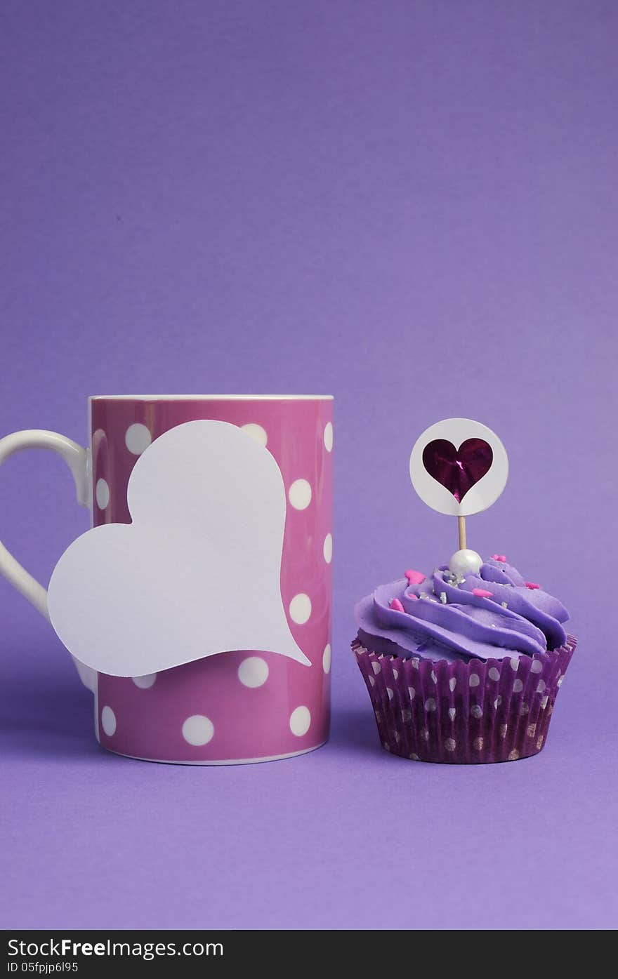 Mauve purple decorated cupcakes for children or teens birthday, or bachelorette, bridal or baby shower party function, with pink polka dot coffee mug and heart gift tag with copy space for your text here. Mauve purple decorated cupcakes for children or teens birthday, or bachelorette, bridal or baby shower party function, with pink polka dot coffee mug and heart gift tag with copy space for your text here.