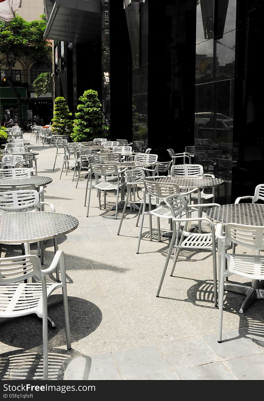 Empty tables and chairs of a sidewalk coffee shop in Ho chi minh city, Vietnam