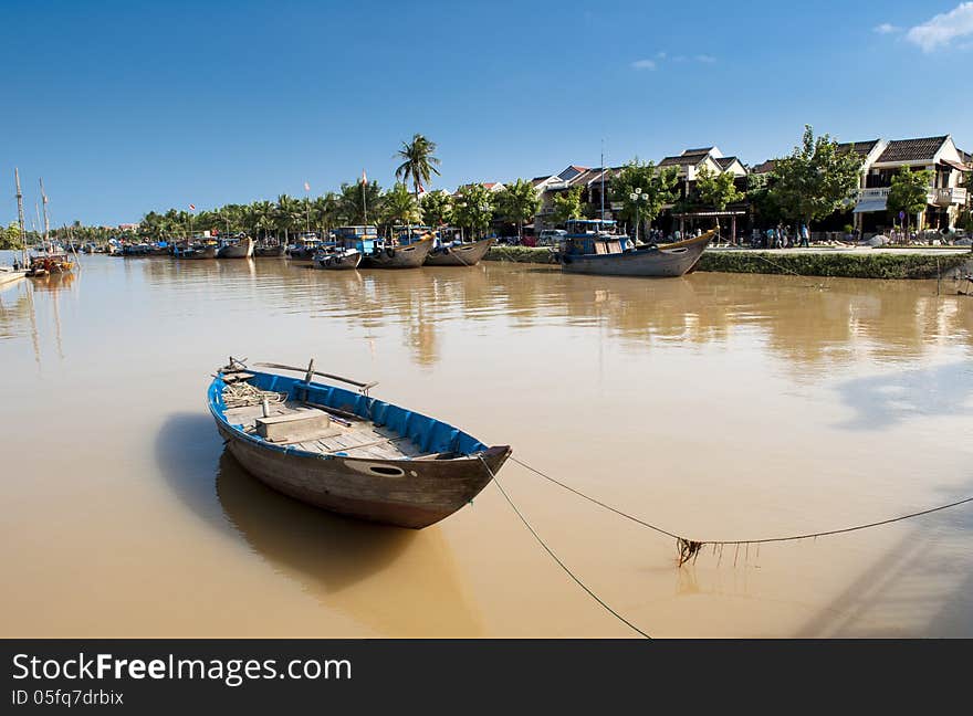 Rowboat On The River With The Ancient Town At Background