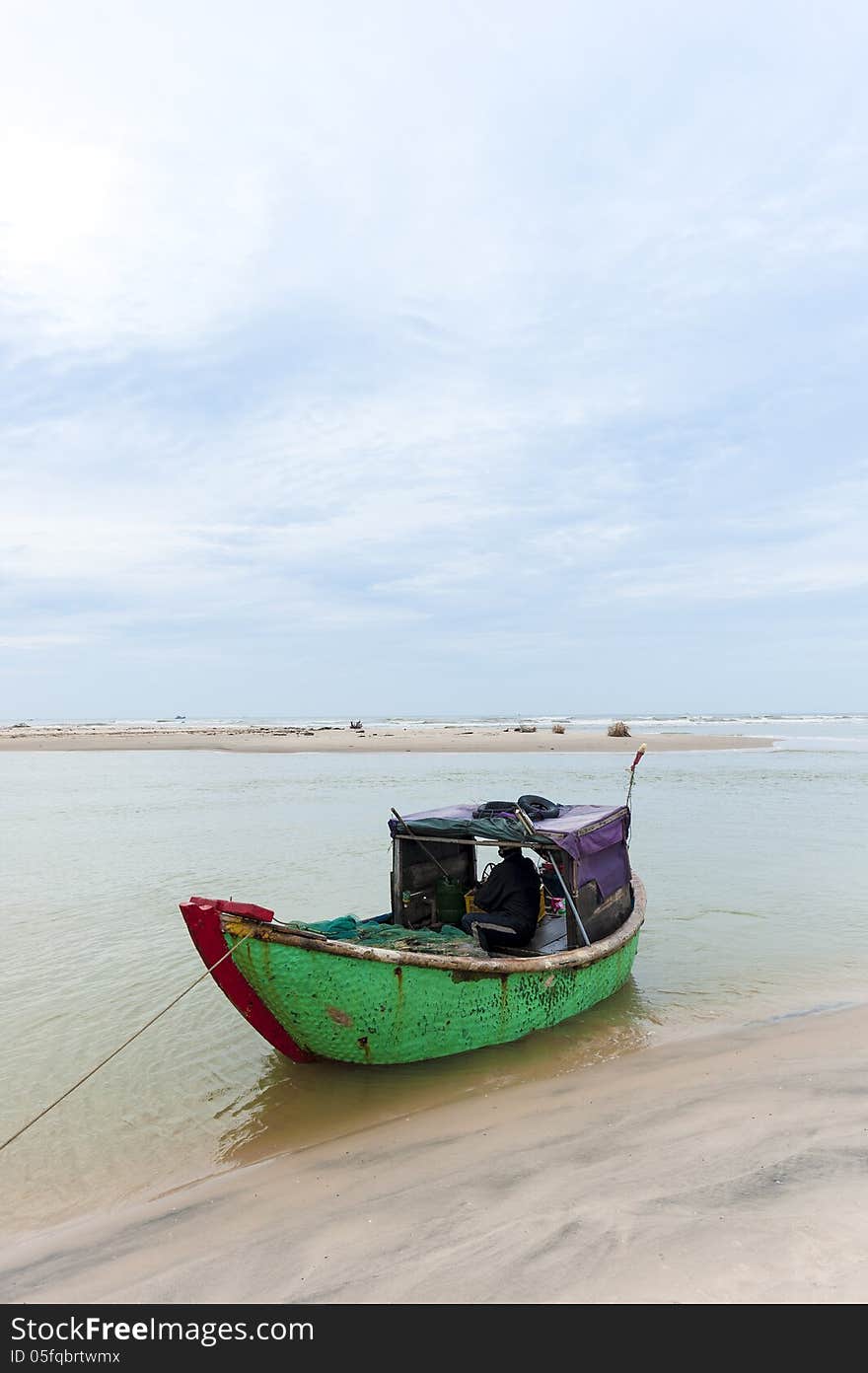 Man fishing boat at the shore-line