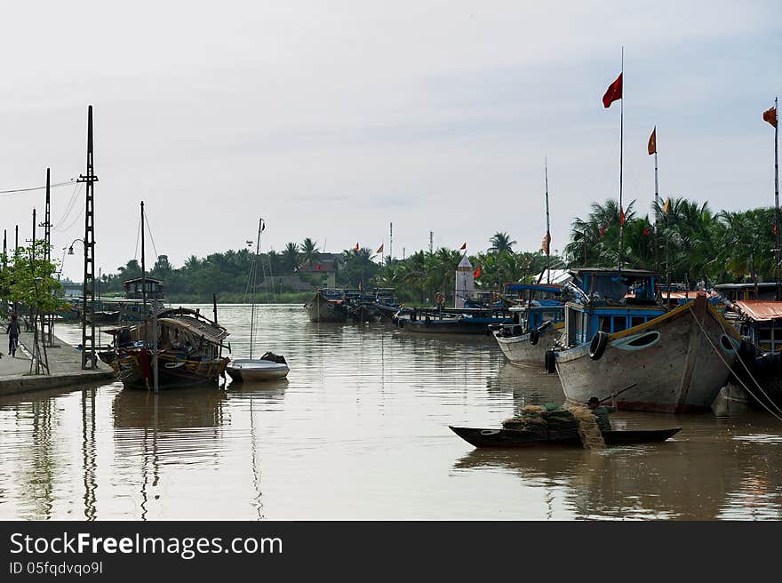 Man rowing a boat with the fishing net on the river of Hoi An