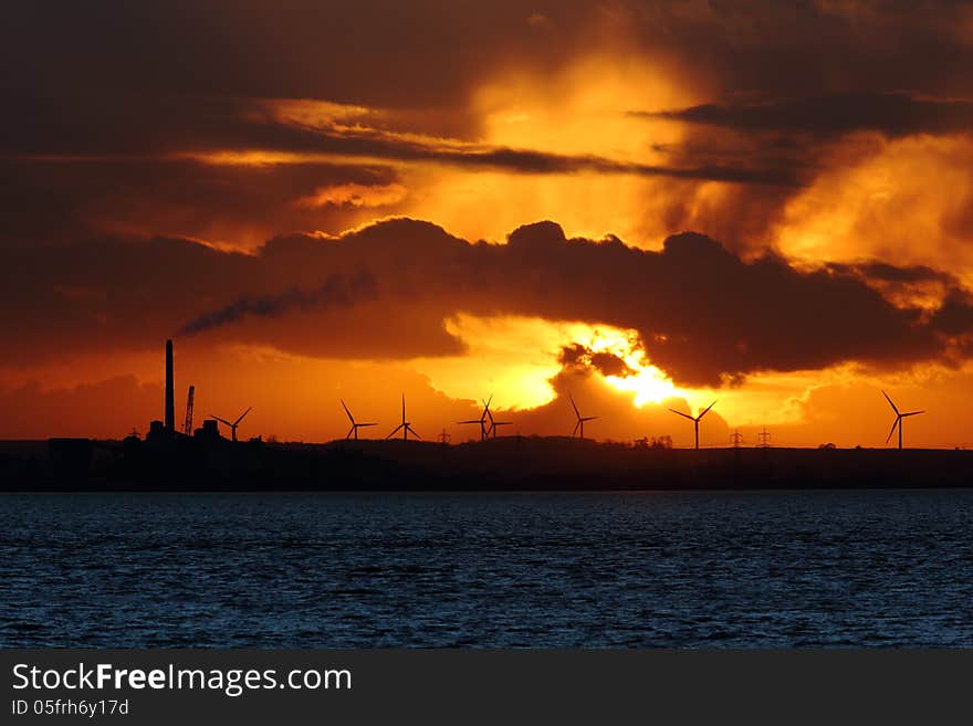 Sunset on sea and wind turbines