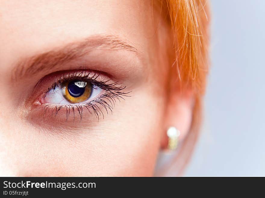 Eye of young beautiful woman with red hair