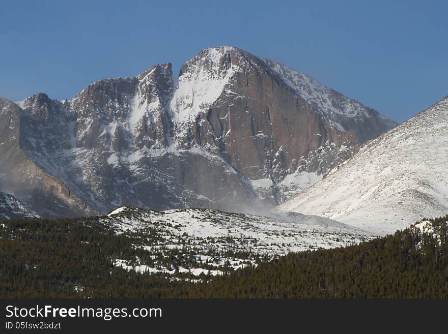 Rugged Longs Peak in Colorado following a snow storm as the clouds lift and as fog begins to clear. Rugged Longs Peak in Colorado following a snow storm as the clouds lift and as fog begins to clear.