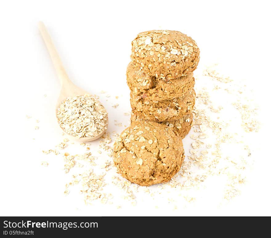 Oatmeal in the wood spoon and cookies on white background