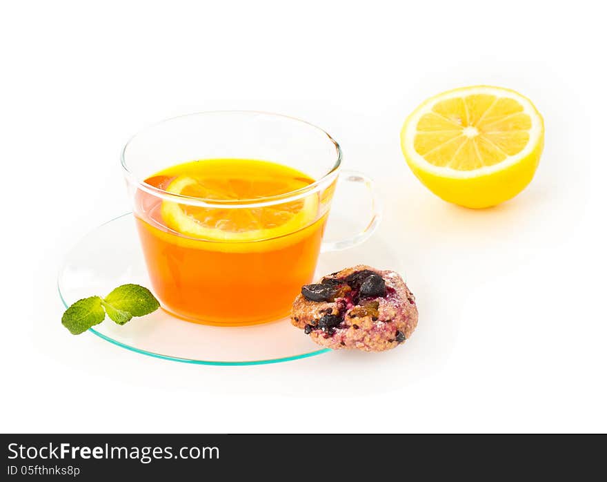 Tea with lemon, cookie and mint on white background, closeup