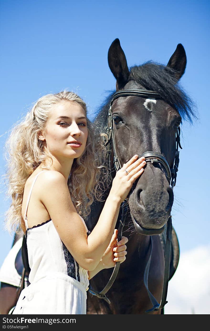 Beautiful girl with black horse at summer field. Beautiful girl with black horse at summer field