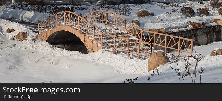 Old arch bridge in the snow, the silent deserted.