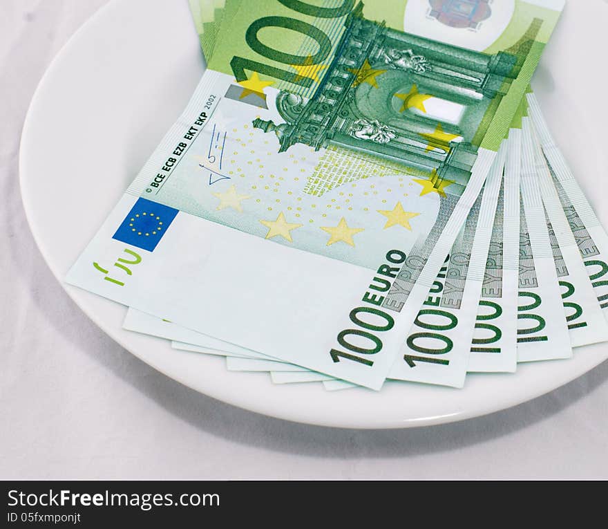 100 euro banknotes on a white plate. 100 euro banknotes on a white plate