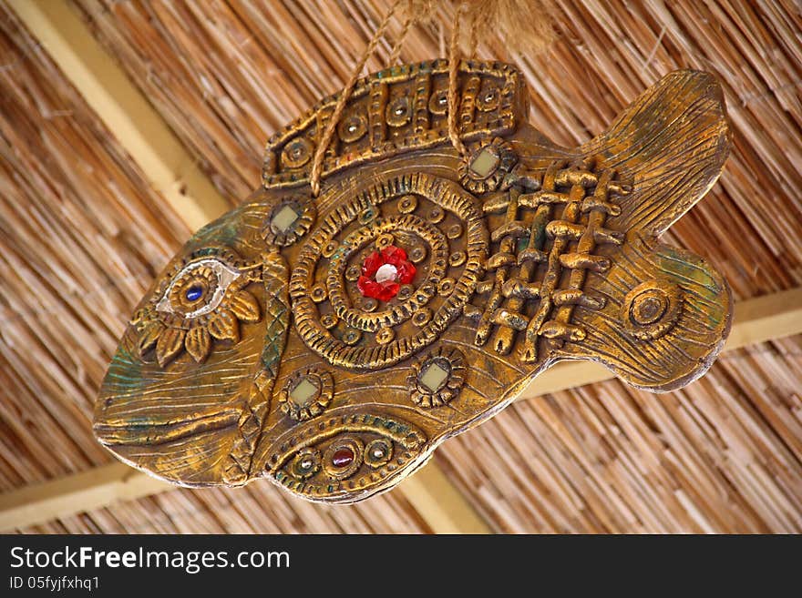 Decorative fish hanging under a thatched ceiling