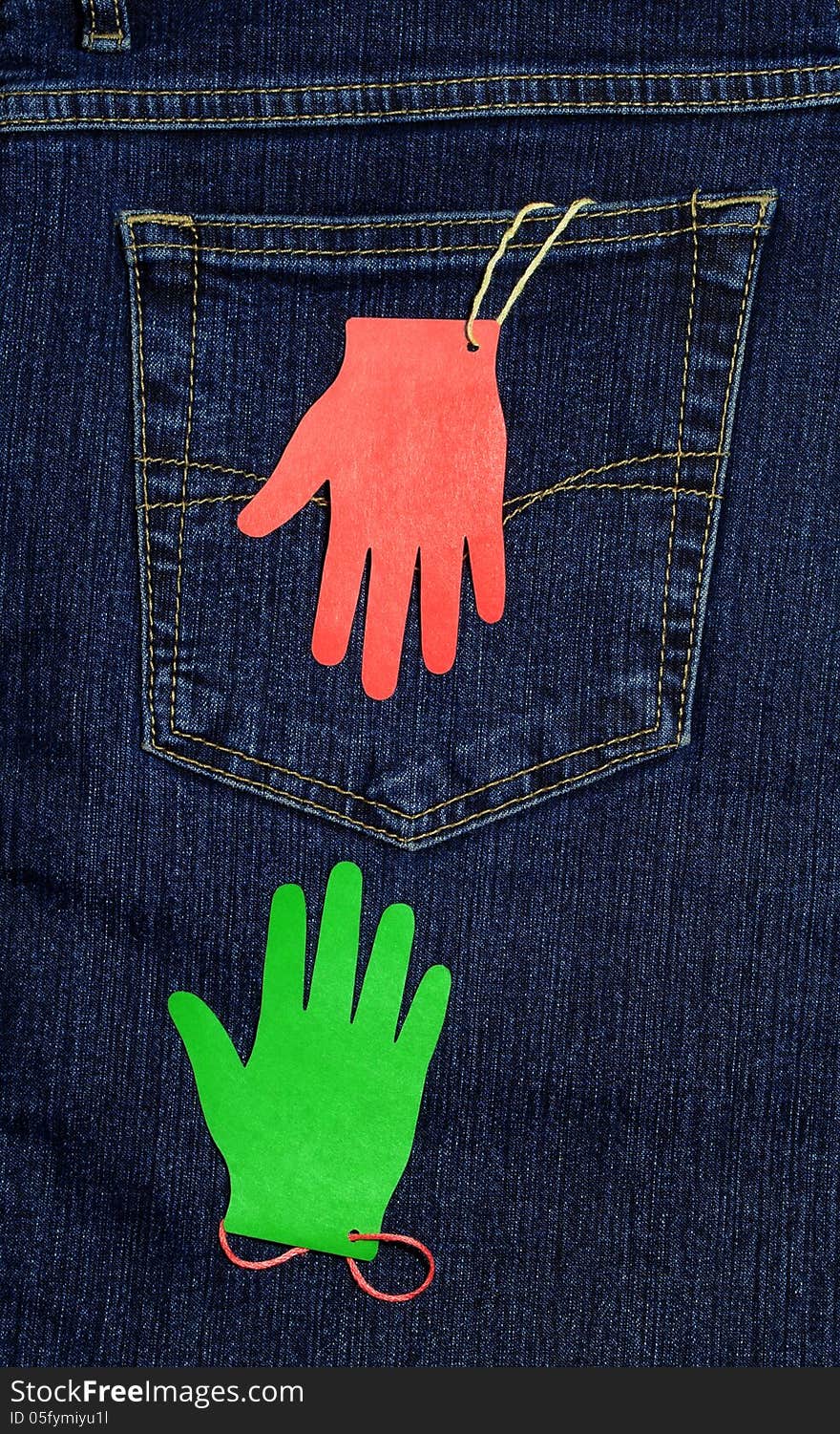 Two paper palms with threads at the back pocket of jeans, are drawn to each other. Two paper palms with threads at the back pocket of jeans, are drawn to each other