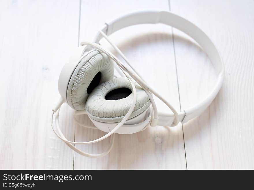 White  Headphones On Wooden  Background