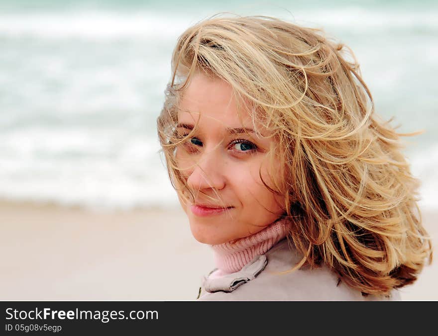 Young attractive woman near the sea on spring day