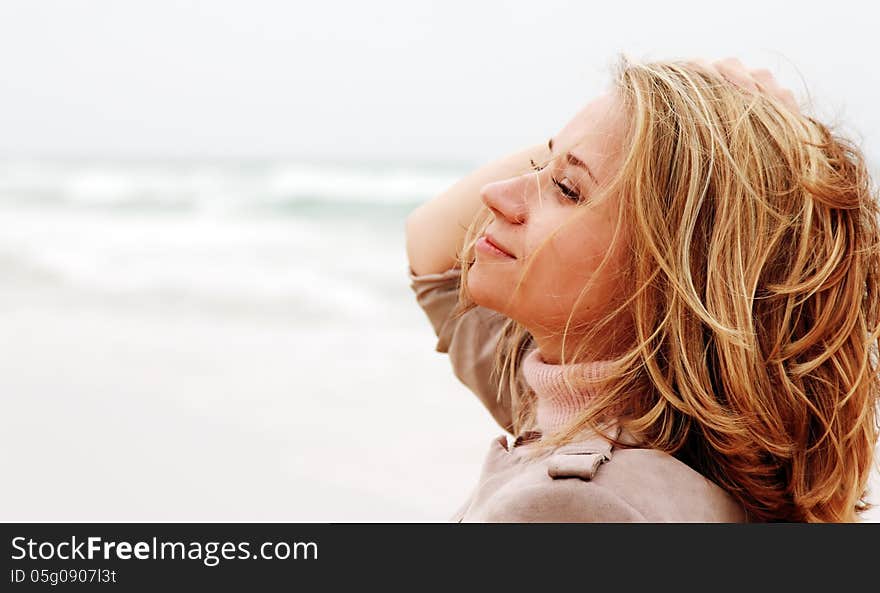 Young attractive woman near the sea on spring day