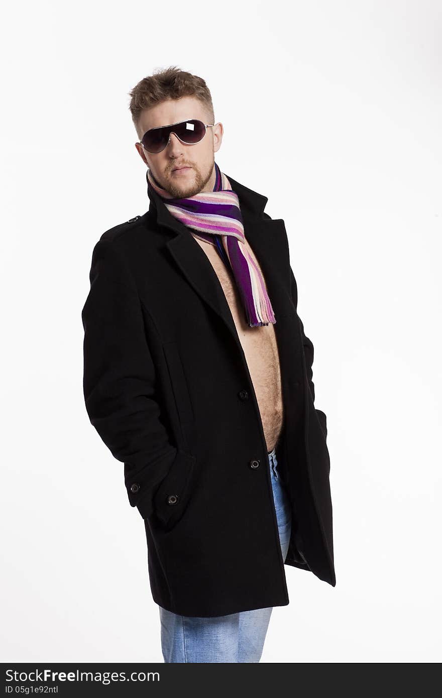 Portrait of handsome stylish blond man in sunglasses and a coat over her naked body in a beautiful stylish scarf