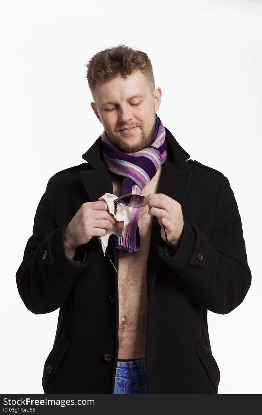 Portrait of handsome stylish blond man in sunglasses and a coat over her naked body in a beautiful stylish scarf