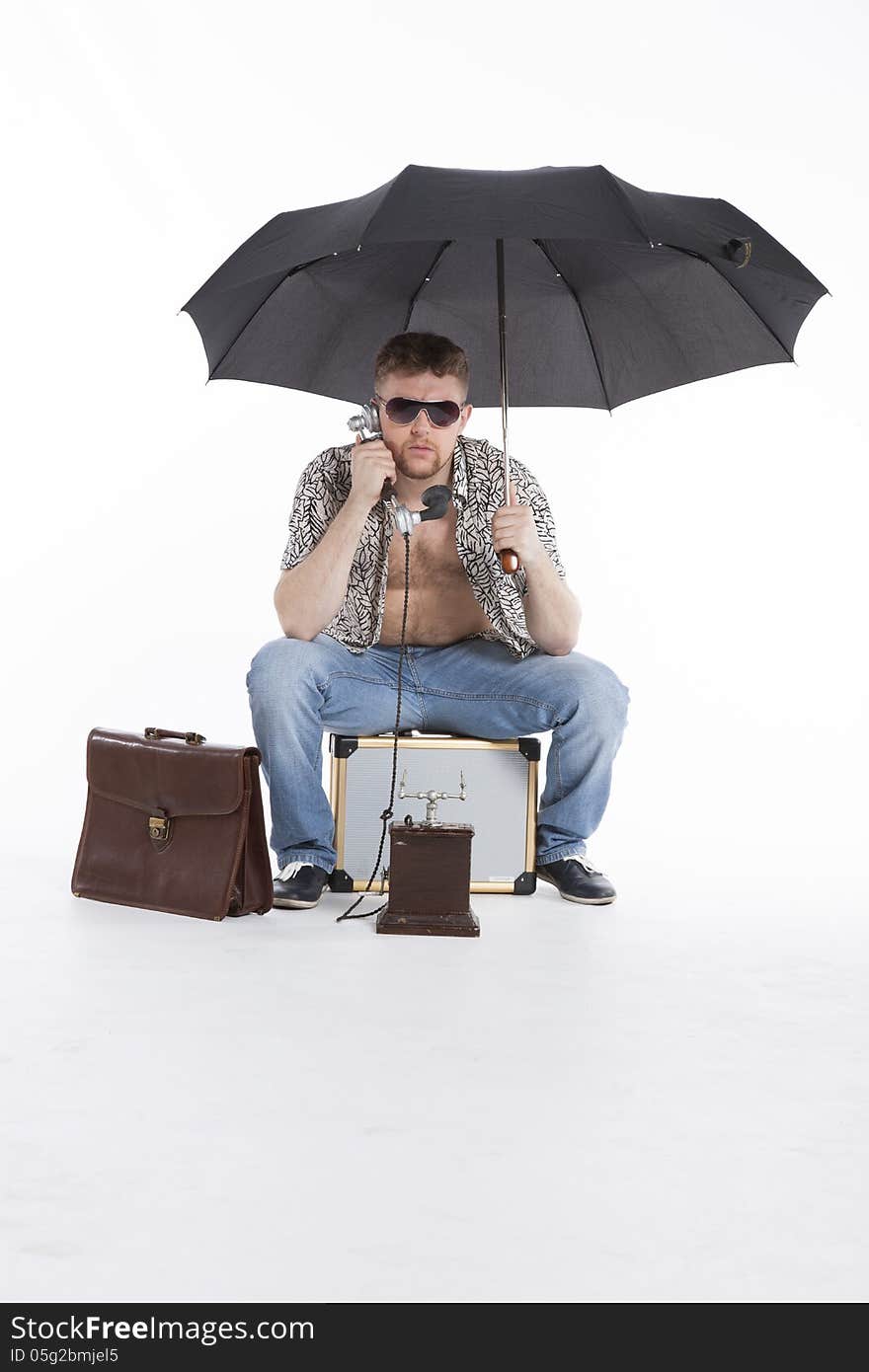 Young businessman under umbrella on vacation. Young businessman under umbrella on vacation