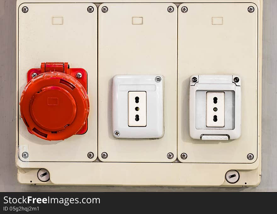 Frontal close up of electric sockets with a red protection. Frontal close up of electric sockets with a red protection.