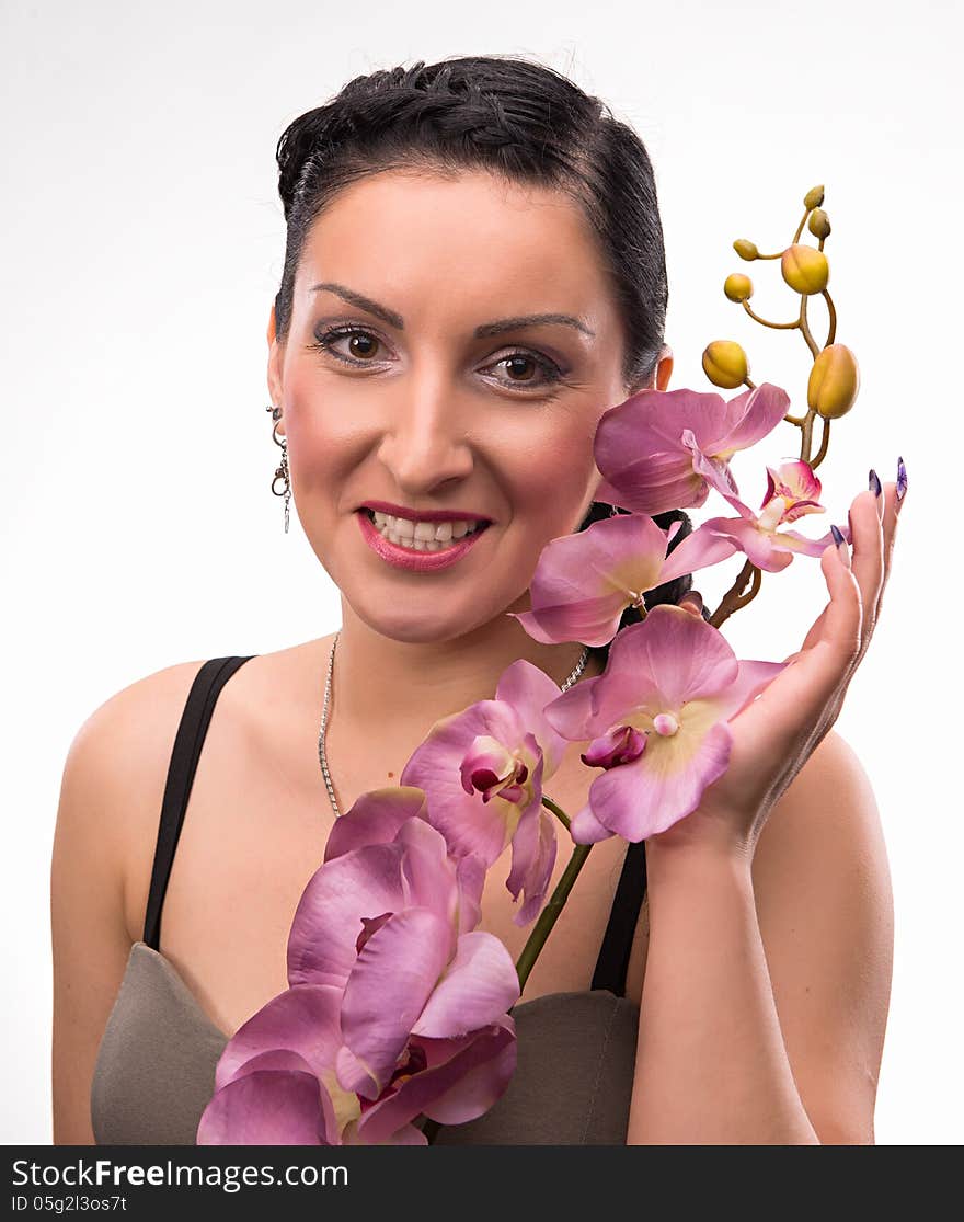 Young woman with beautiful hairstyle and pink orchid on a white background