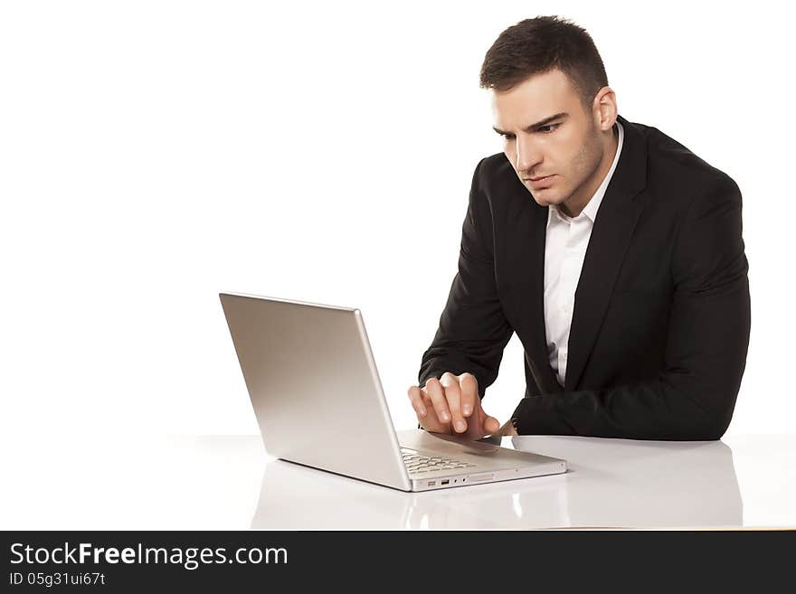 Concentrated young businessman working on his laptop. Concentrated young businessman working on his laptop