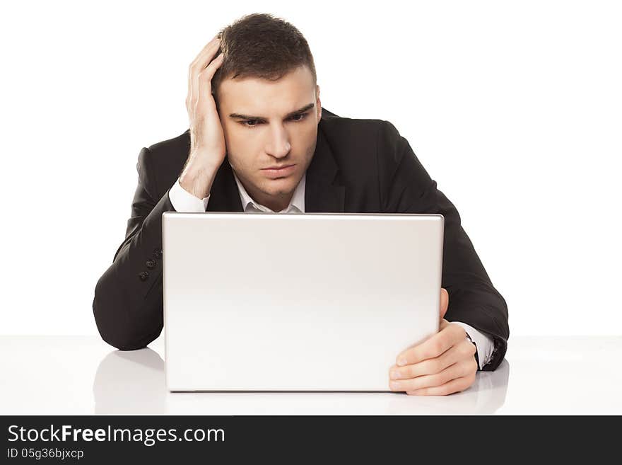 Young businessman stunned and amazed staring at his laptop. Young businessman stunned and amazed staring at his laptop