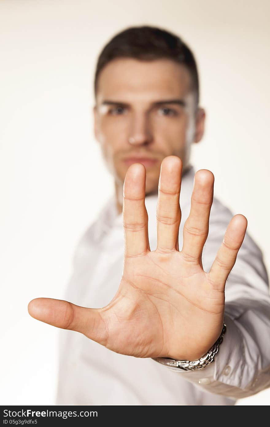 Angry attractive young man showing stop hand