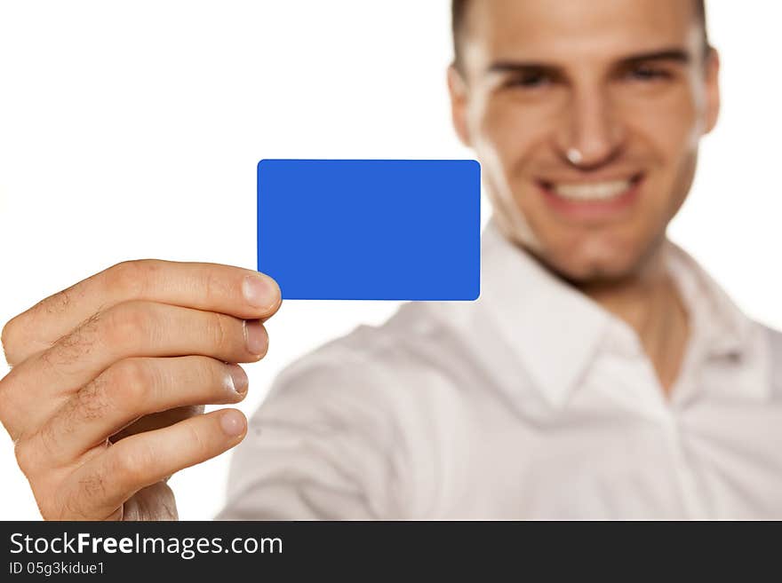 Smiling attractive young man, holding a plastic card in his hand