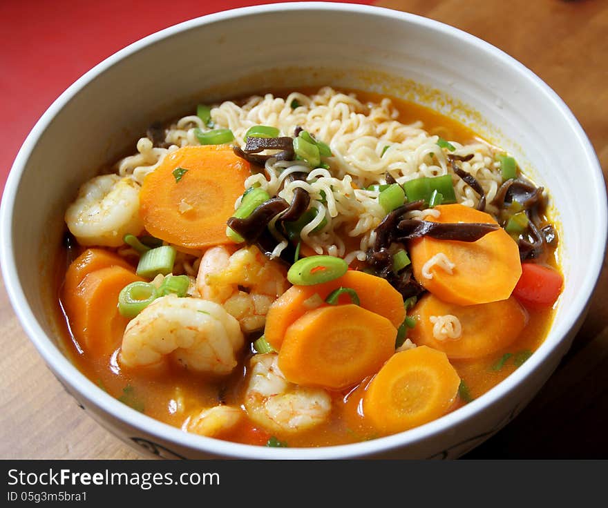 Bowl of Asian noodle soup with prawns and vegetables