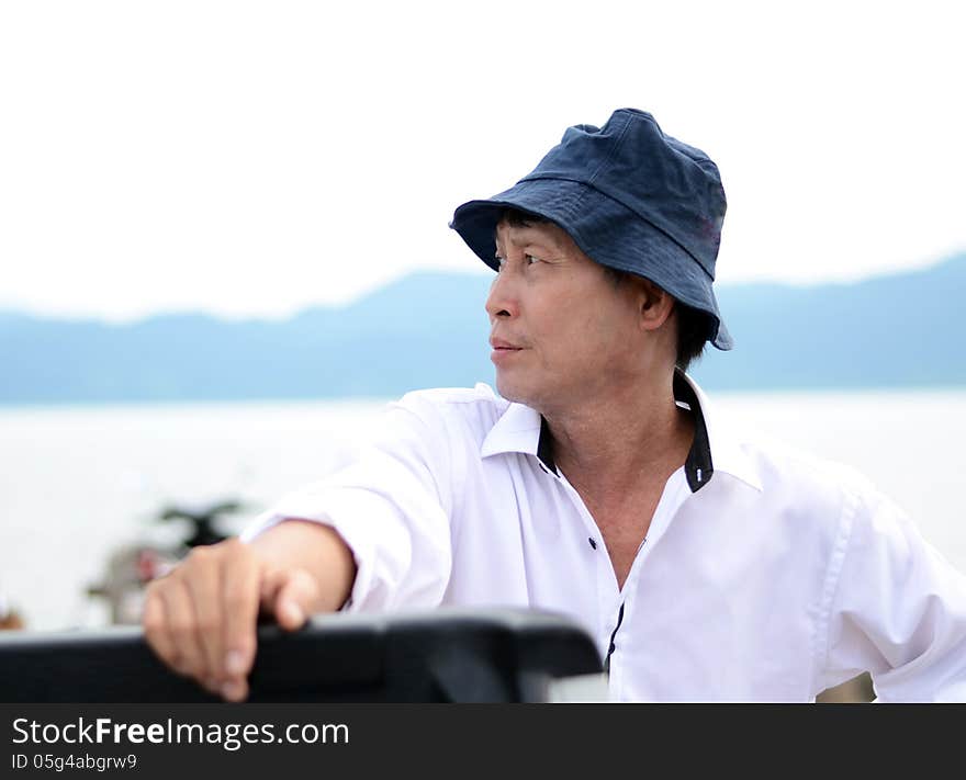 Middle-aged fisherman with sea in background