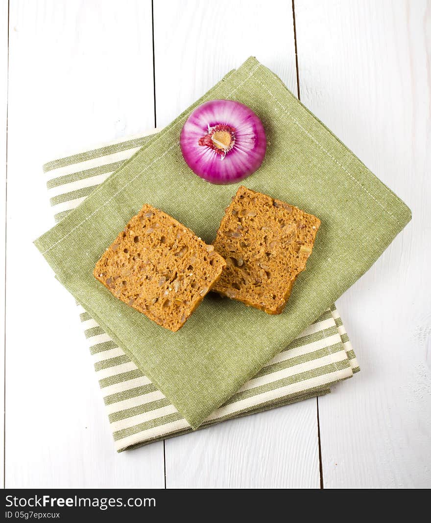 Bread slices and onion on napkins, on wooden background. Bread slices and onion on napkins, on wooden background