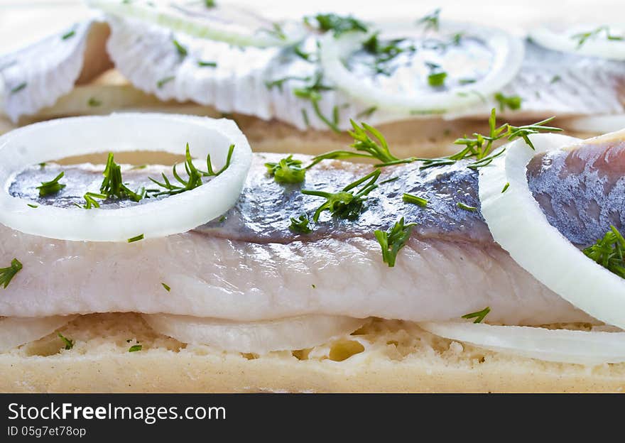 Sandwiches with herring, onions and herbs, closeup