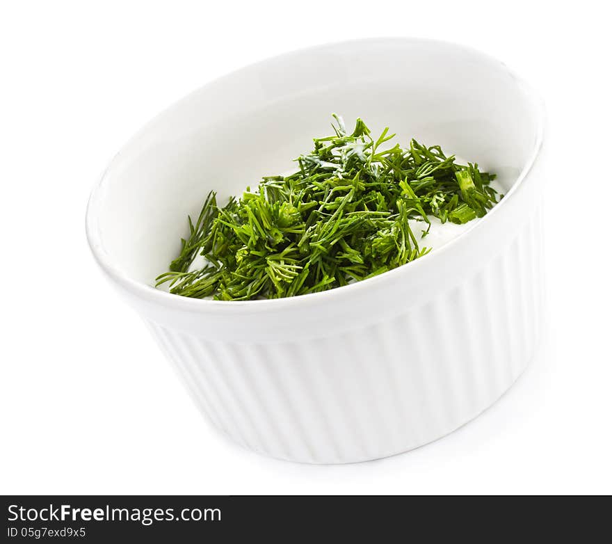 Sour cream in small round plate with herbs, isolated