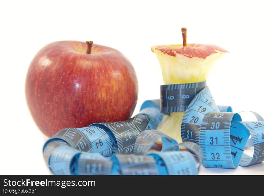 Red apple and apple core with tape measure isolated on white background