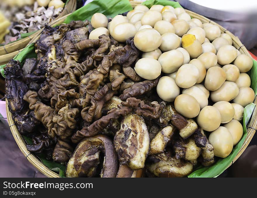 Boiled eggs, and pork cooked on a banana leaf basket