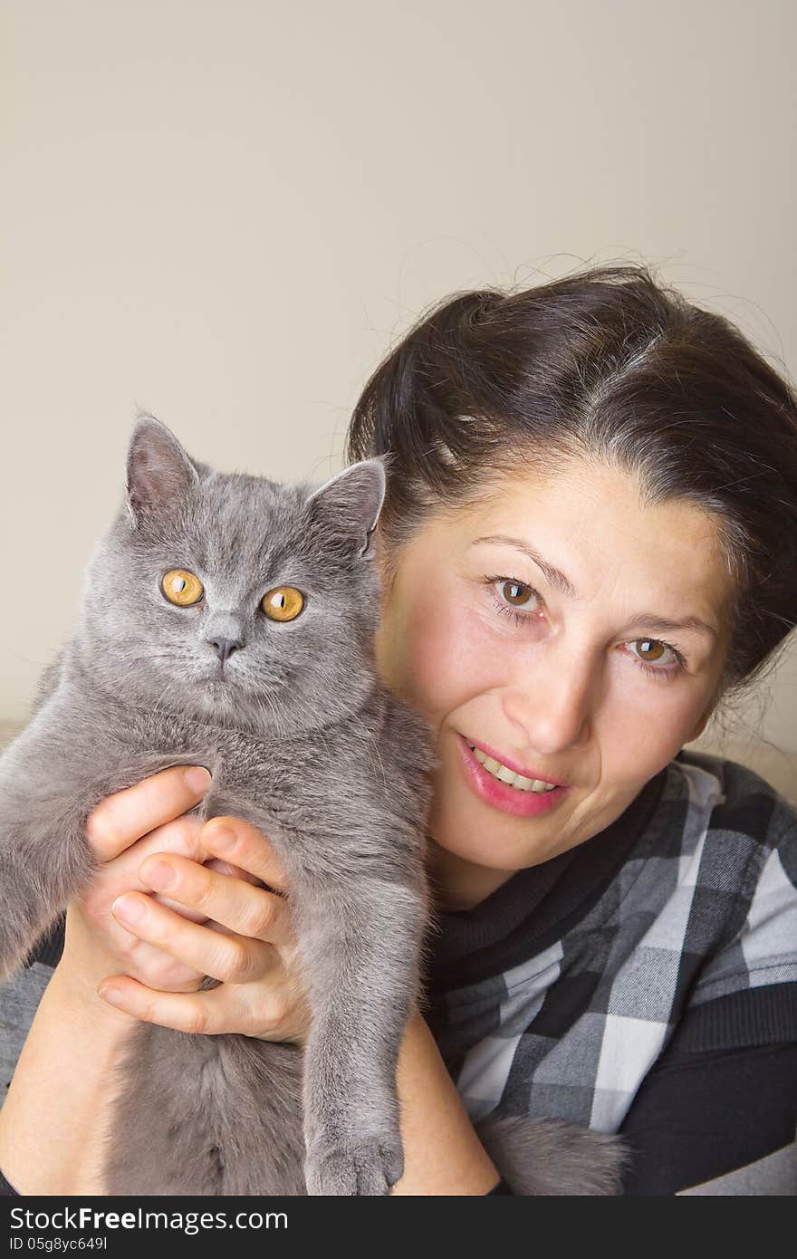 Pretty woman with a gray cat British breed. Pretty woman with a gray cat British breed