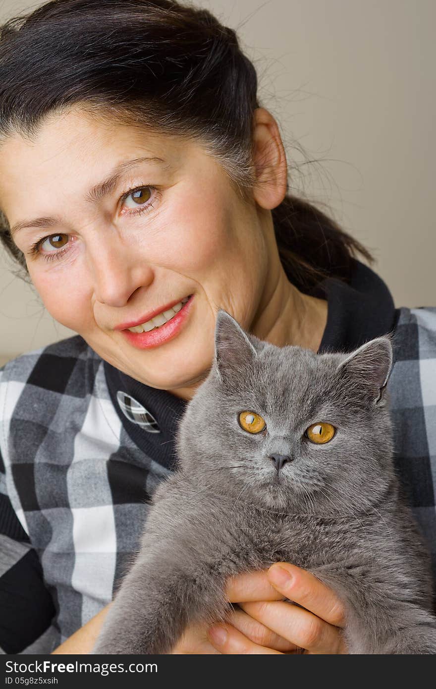 Pretty woman with a gray cat British breed. Pretty woman with a gray cat British breed