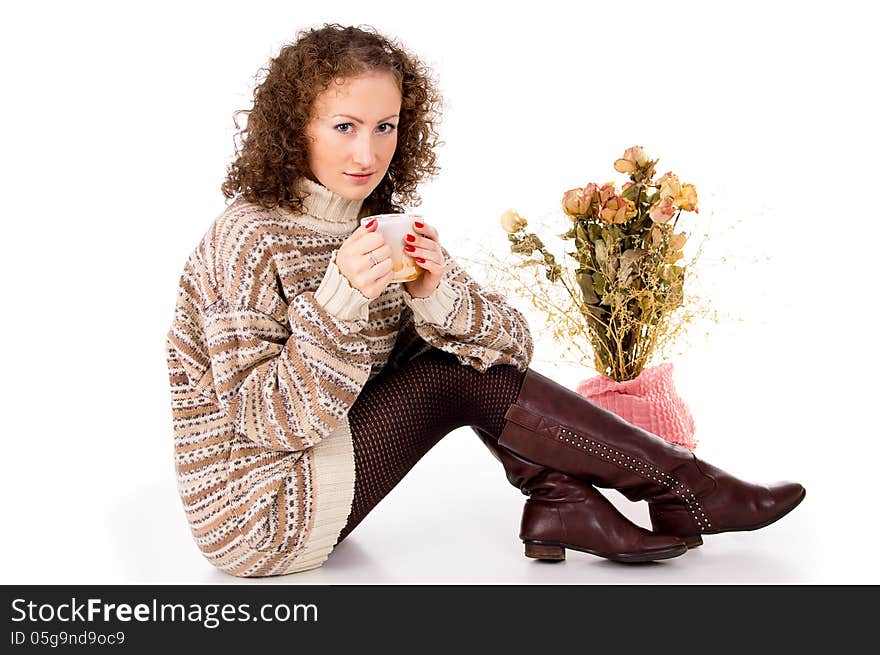 Beautiful girl sitting in a sweater with a mug of tea