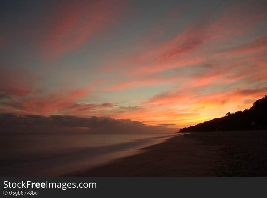 The photograph shows sunrise over the sea, the sun is still over the horizon, but already his light illuminates and turns red clouds. Due to the long exposure time was achieved blur the surface. The photograph shows sunrise over the sea, the sun is still over the horizon, but already his light illuminates and turns red clouds. Due to the long exposure time was achieved blur the surface.